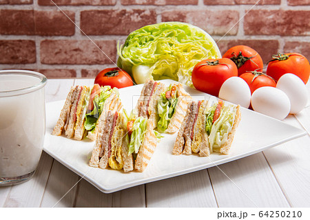 朝食、サンドイッチ、ハンバーガー、パンケーキ、卵、野菜、コーヒーで、ダイニングテーブル 朝食、サンドイッチ、ハンバーガー、パンケーキ、卵、野菜、コーヒーで、ダイニングテーブル 64250210
