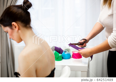 Female physiotherapist applying sport tape on the patient shoulder after her injury, healthcare concept 64251489