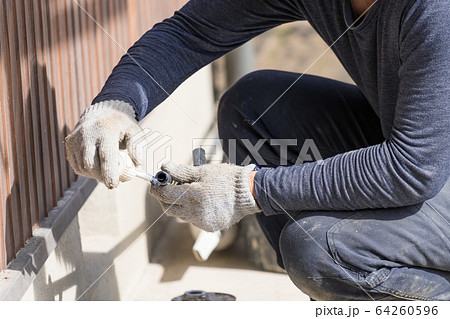 水道工事　接着剤を塗っている配管工 64260596