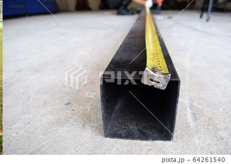 Measure the length of black iron with a yellow tape. Measure the length of black iron with a yellow tape. 64261540