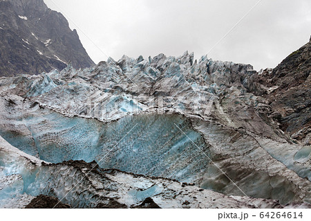 Glacier with deep crevasses covered with snow and 64264614