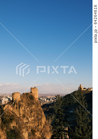 Sunlit high wall at part of fortress and blue sky 64264616