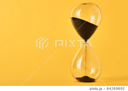 Hourglass on the yellow background with copy 64269692