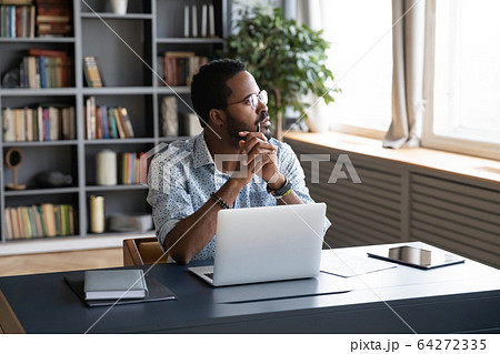 Distracted from study job young biracial man lost in thoughts. 64272335