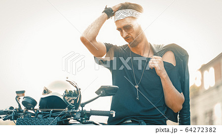 Biker Standing Near Motor Scooter In Backlight 64272382