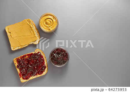 Sandwiches or bread toast with peanut butter and fruit jelly. Top view. Sandwiches or bread toast with peanut butter and fruit jelly. Top view. 64273953