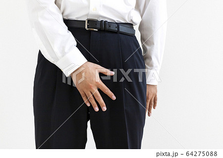 股間を押さえるワイシャツを着た男性 64275088