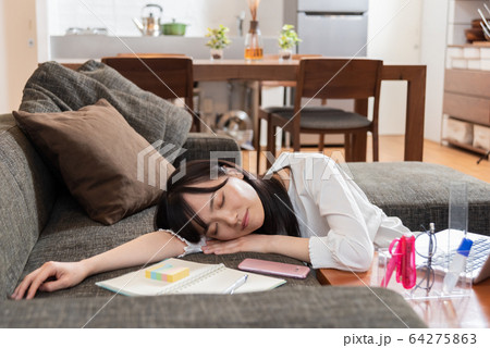 リビングのソファに横たわる若い女性 64275863