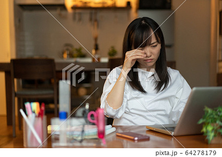 深夜まで自宅で仕事をする若い女性の写真素材