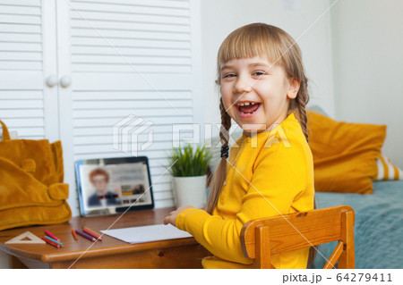 Laughing girl using tablet at home. Distance Laughing girl using tablet at home. Distance 64279411