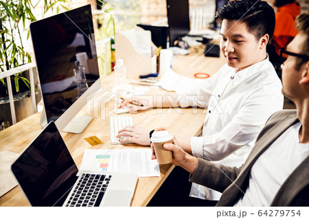 Male colleagues working on business project in office 64279754