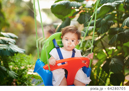 Portrait of baby girl on swings 64280705