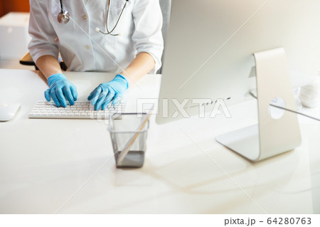 Cropped photo of doctor typing on keyboard of computer 64280763