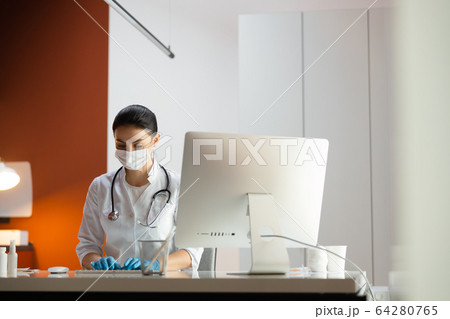 Caucasian doctor in medical mask working at laptop 64280765