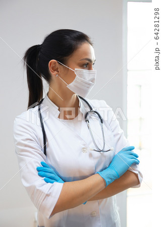 Caucasian pretty pediatrician in medical mask looking aside Caucasian pretty pediatrician in medical mask looking aside 64281298