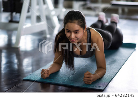 Attractive woman plank with ball in gym 64282145