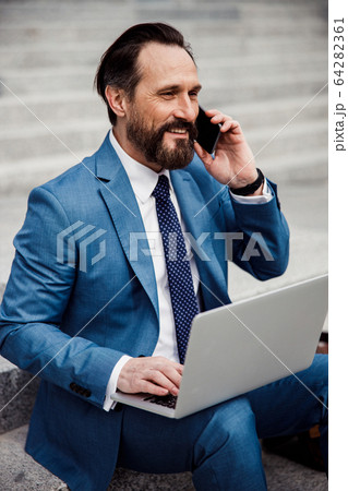 Good-looking contented businessman talking on the phone 64282361