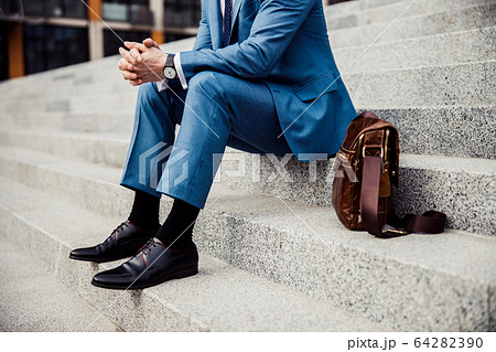 Male in a trendy suit relaxing outdoors Male in a trendy suit relaxing outdoors 64282390