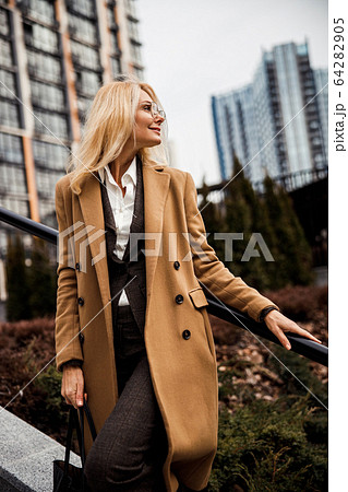 Pleased lady holding a leather tote bag 64282905