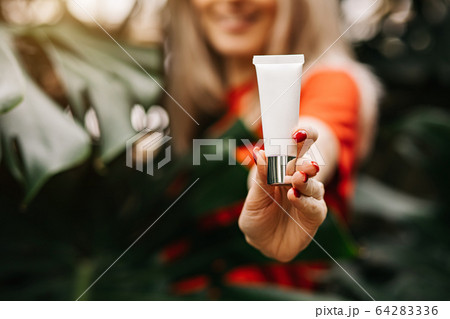 Beautiful woman holding beauty product Beautiful woman holding beauty product 64283336