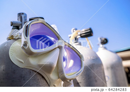 A diving mask hanging on the oxygen tank for scuba 64284283
