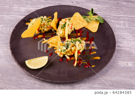 Guacamole with avocado and chopped greens, served with chips, ketchup and mustard 64284385