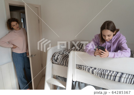 Mom worried about teen daughter obsessed with mobile phone 64285367