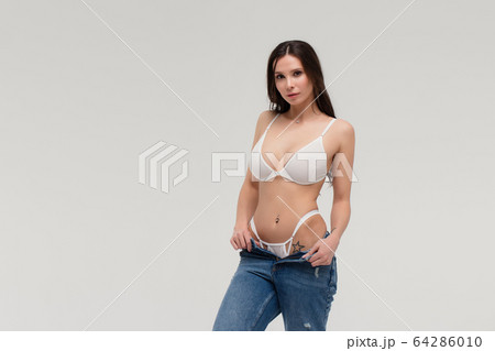 Alluring woman in white lingerie and jeans with Alluring woman in white lingerie and jeans with 64286010