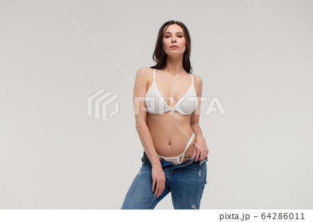 Alluring woman in white lingerie and jeans with Alluring woman in white lingerie and jeans with 64286011