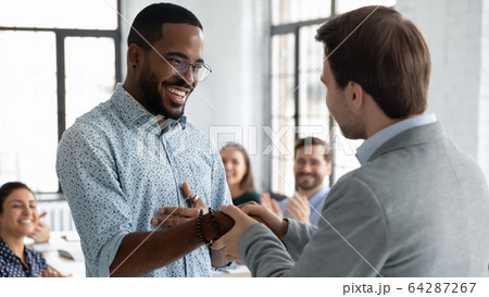 Multiracial businessmen handshake closing deal at meeting Multiracial businessmen handshake closing deal at meeting 64287267