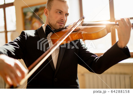 young caucasian violinist play classical instrument 64288158
