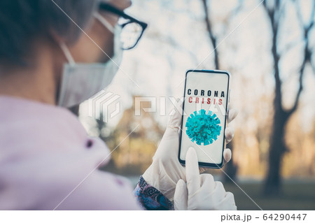 Senior woman using Coronavirus tracking app on her phone 64290447