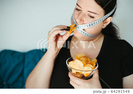 Obese woman with unhealthy food, eating disorder Obese woman with unhealthy food, eating disorder 64291549