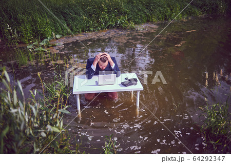 Frustrated depressed man holding head in hands shocked by bankruptcy stock downfall sitting at work desk with laptop, stressed tired businessman feels despair. Business in the swamp. Frustrated depressed man holding head in hands shocked by bankruptcy stock downfall sitting at work desk with laptop, stressed tired businessman feels despair. Business in the swamp. 64292347