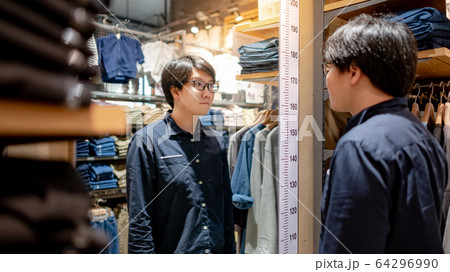 Asian man looking at himself in the mirror in 64296990