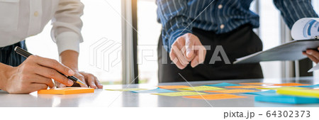 young business workers posting with sticky notes 64302373