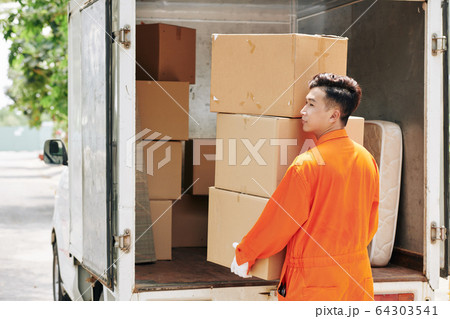 Man carrying stack of cardboard boxes Man carrying stack of cardboard boxes 64303541