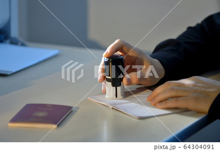 Customs Officer Stamping a Passport 64304091