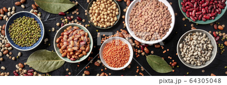 Legumes flat lay panorama, shot from the above on a black background. Lentils, soybeans, chickpeas, red kidney beans, a vatiety of pulses 64305048