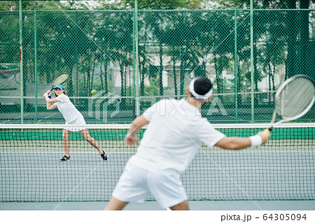 Female tennis player hitting ball Female tennis player hitting ball 64305094