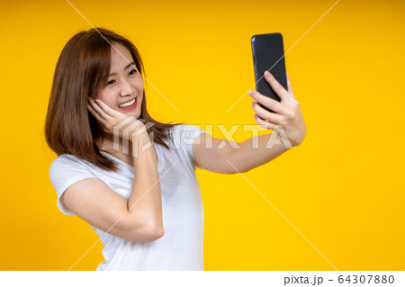 Happy young Asian woman posing isolated over 64307880