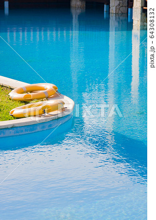 Lifebuoys by outdoor pool at luxury hotel.  64308132