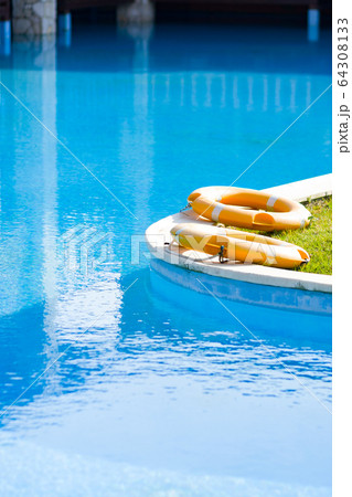 Lifebuoys by outdoor pool at luxury hotel.  64308133