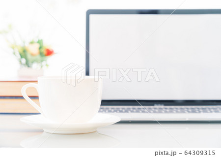 Cup of coffee with blank screen laptop computer on 64309315