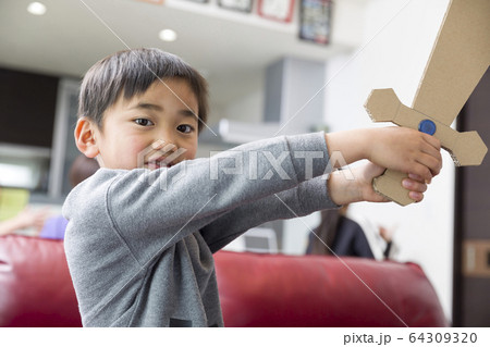 手作りの玩具で室内遊びをする小学生男の子の写真素材