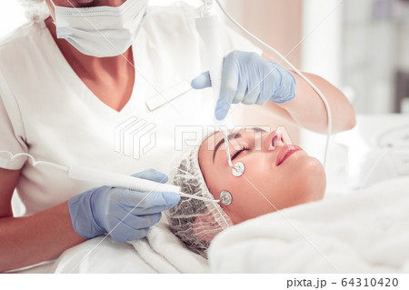 Beauty expert using new equipment for deep facial cleansing Beauty expert using new equipment for deep facial cleansing 64310420