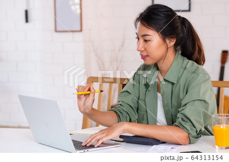 Asian woman use laptop and calculator calculate Asian woman use laptop and calculator calculate 64313154