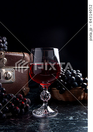 Glass of red wine on dark marble background. 64314052