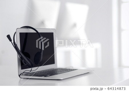 Call center and communication support, customer service help desk. VOIP headset on laptop computer Call center and communication support, customer service help desk. VOIP headset on laptop computer 64314873