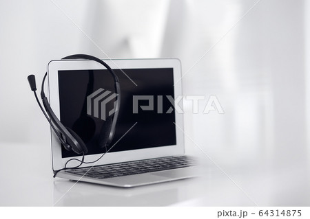 Call center and communication support, customer service help desk. VOIP headset on laptop computer Call center and communication support, customer service help desk. VOIP headset on laptop computer 64314875